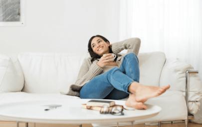 Woman relaxing on couch with mug Woman relaxing on couch with mug